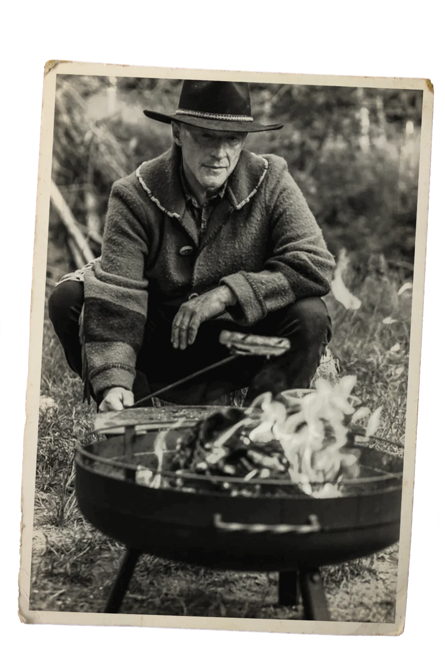 A frontier cook tending chicken over an open fire.
